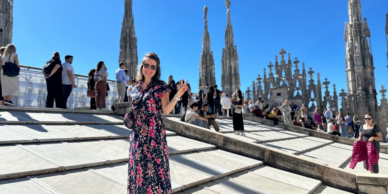 Turytka na dachu katedry duomo w mediolanie, z gotyckimi wieżyczkami w tle.