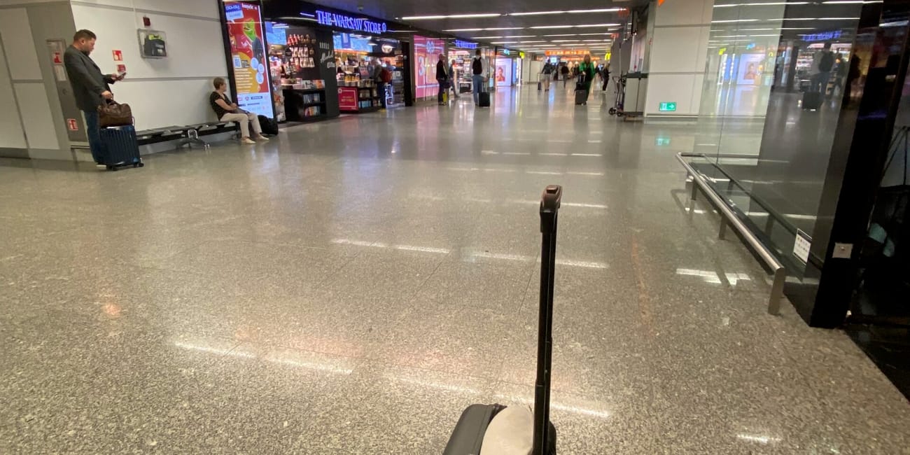 Empty airport terminal with a suitcase left behind near the departure gate signs