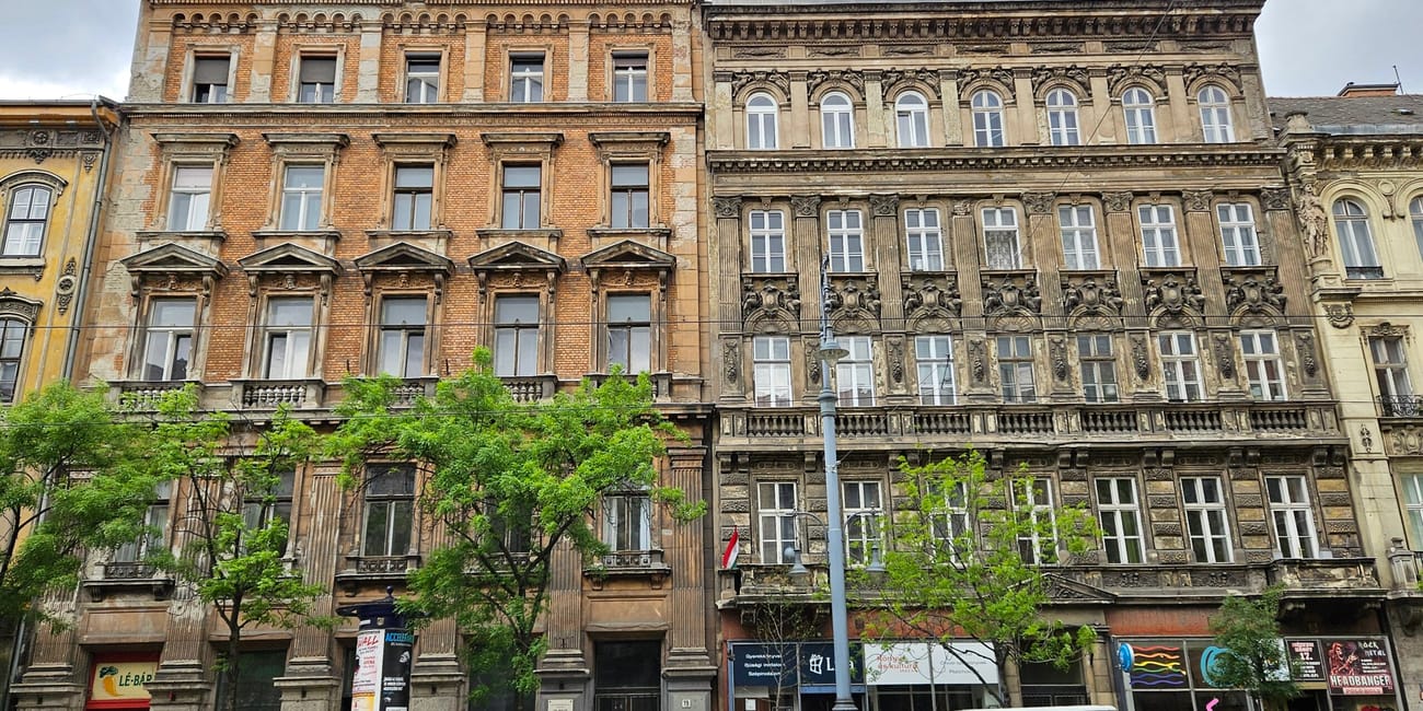 Kamienice w centrum budapesztu z ozdobnymi fasadami i sklepami na parterze