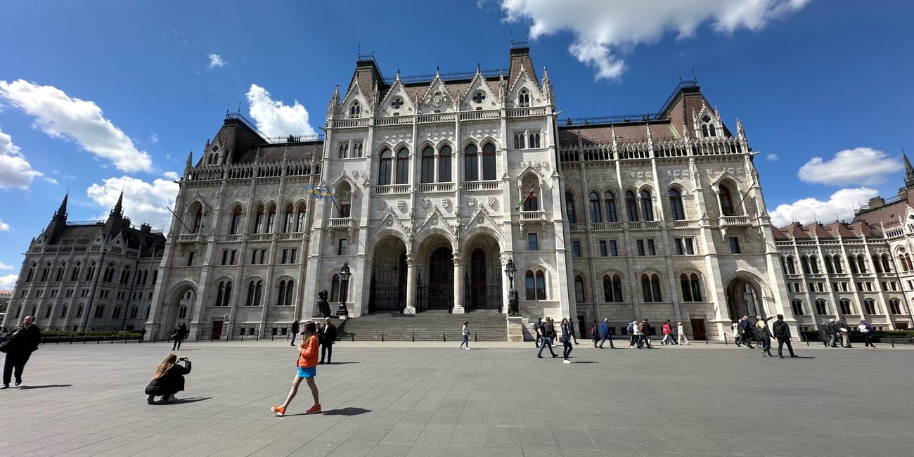 Węgierski parlament w budapeszcie z placem i spacerującymi ludźmi