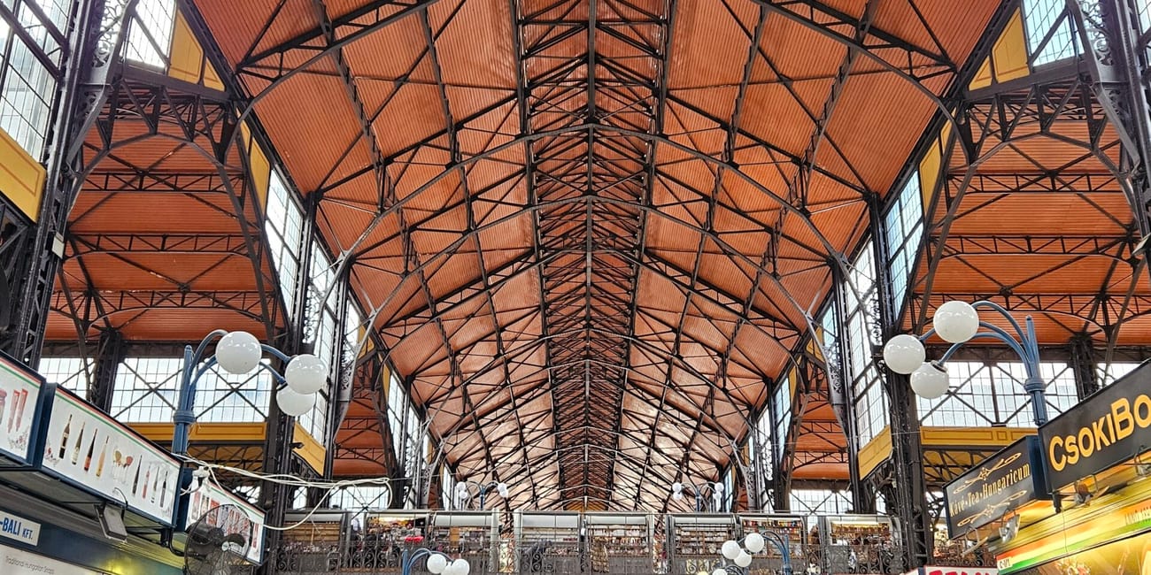 Hala targowa central market hall w budapeszcie z wysokim, stalowym dachem i stoiskami po bokach