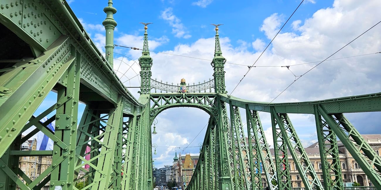 Most wolności w budapeszcie z zieloną kratownicą i torami tramwajowymi pod błękitnym niebem