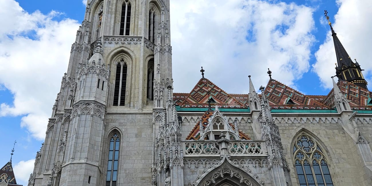 Kościół macieja w budapeszcie z wysoką gotycką wieżą i wejściem pod błękitnym niebem