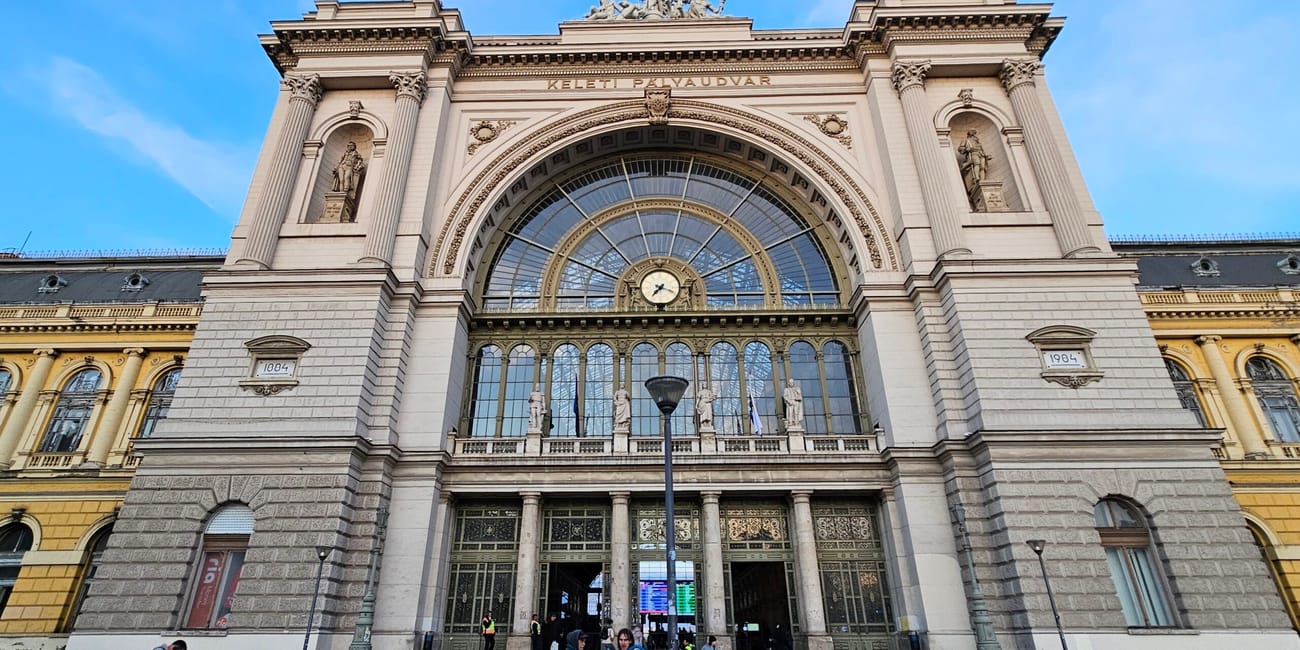 Dworzec keleti w budapeszcie z neoklasyczną fasadą i dużym zegarem.