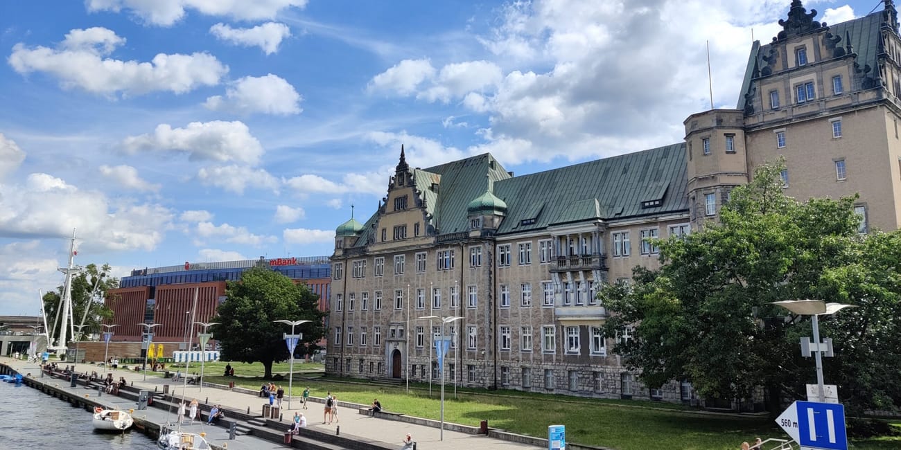 Bulwar nad odrą w szczecinie z historycznym budynkiem i zacumowanymi łodziami