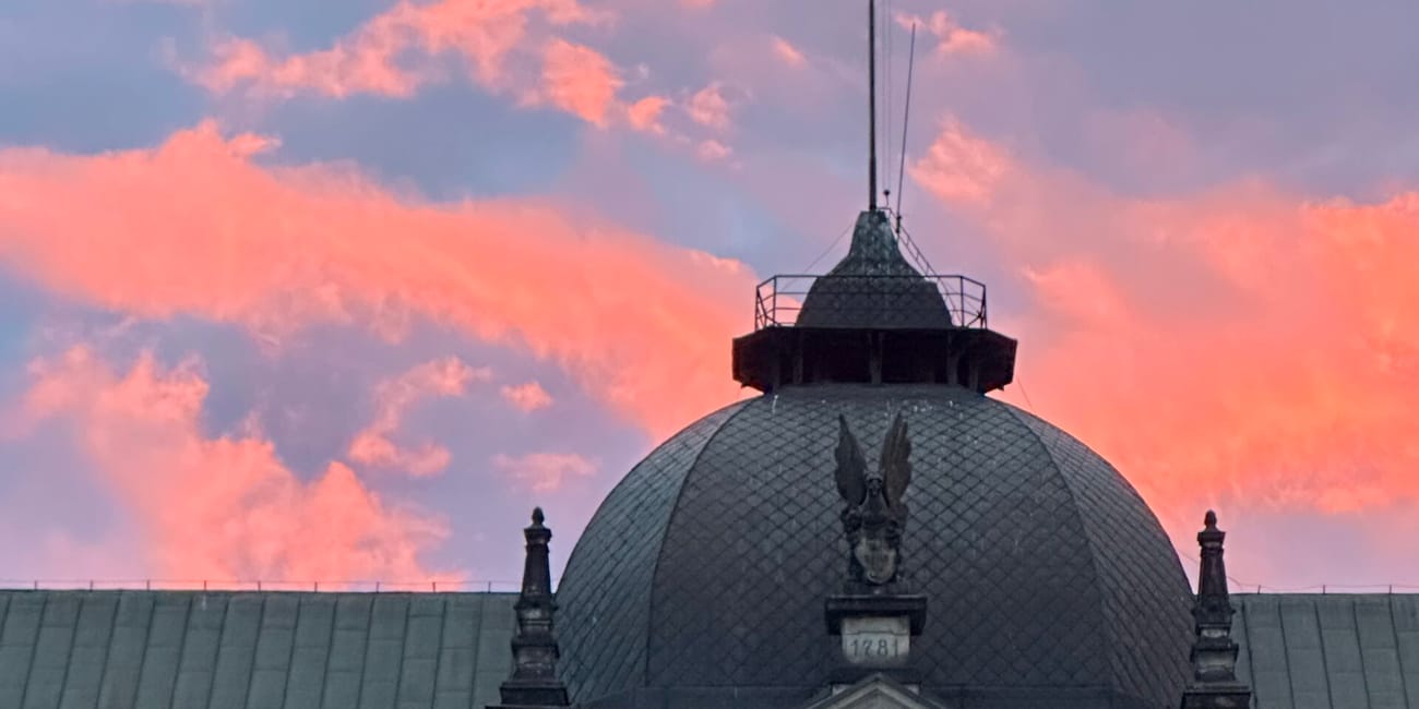 Wały chrobrego w szczecinie z kopułą budynku na tle różowego nieba o zachodzie słońca