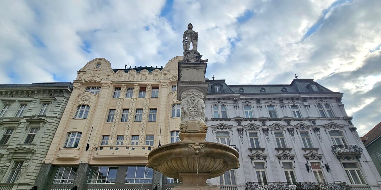 Fontanna roland w bratysławie na tle zabytkowych kamienic.