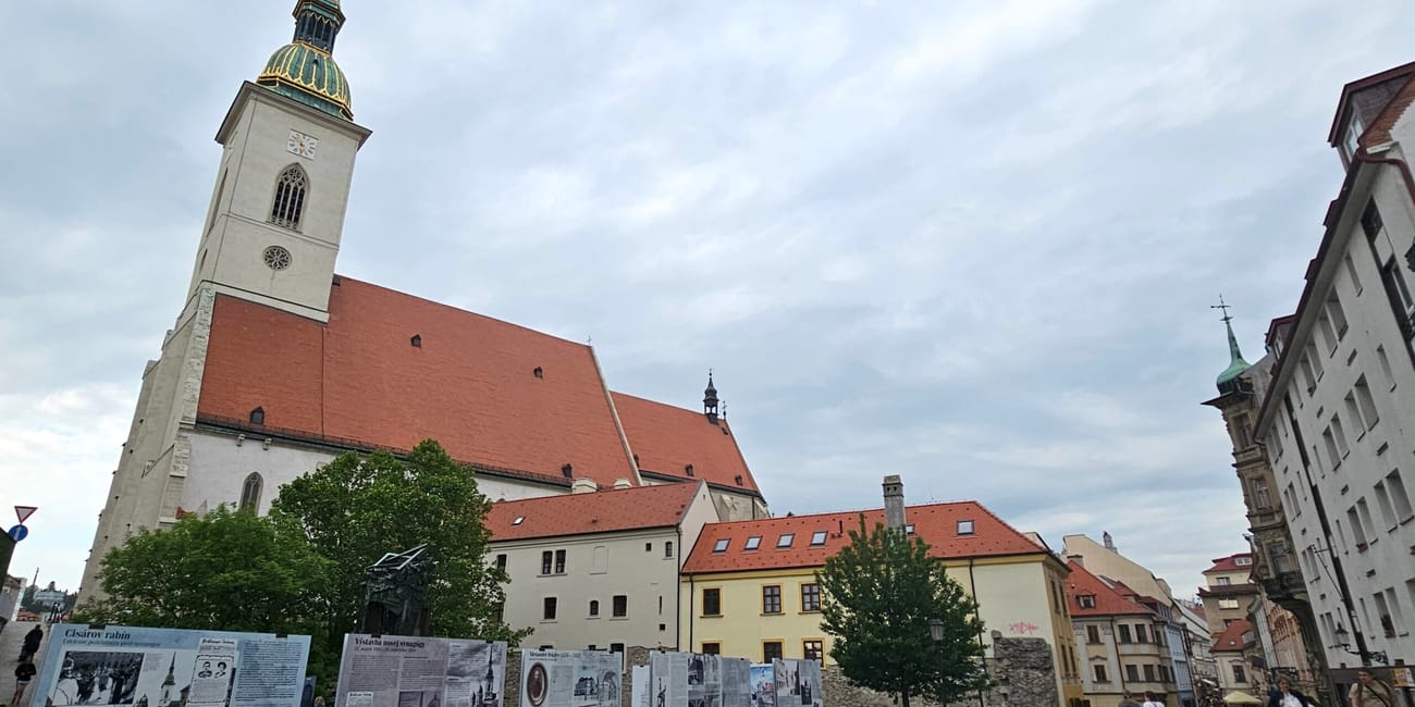 Katedra św. Marcina w bratysławie z wysoką wieżą i czerwonym dachem pod pochmurnym niebem
