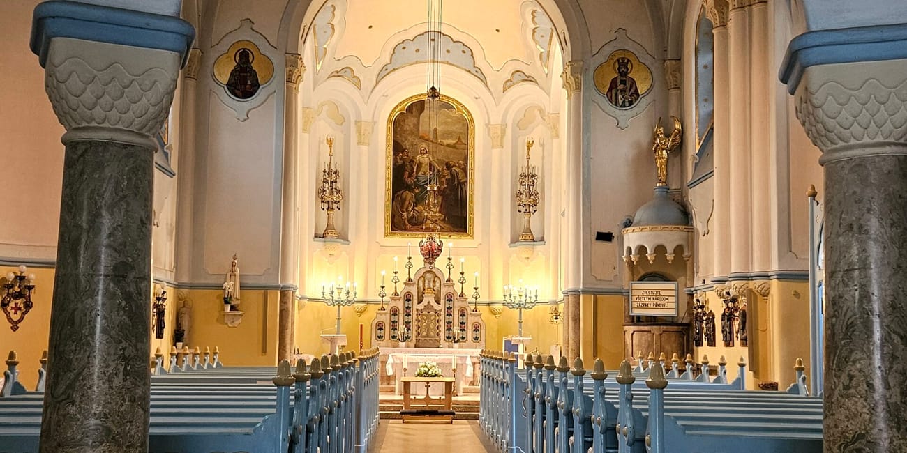 Wnętrze kościoła św. Elżbiety w bratysławie z nawą, ławkami i ołtarzem