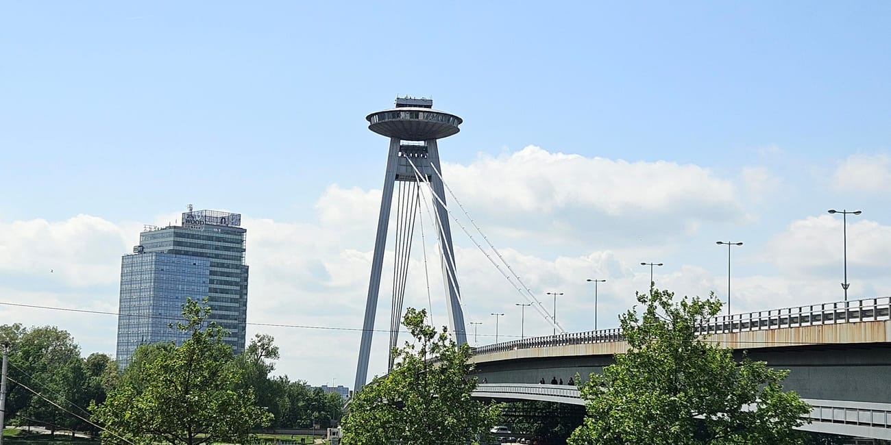 Most ufo bridge w bratysławie nad rzeką dunaj, z wieżą i mostem w tle.