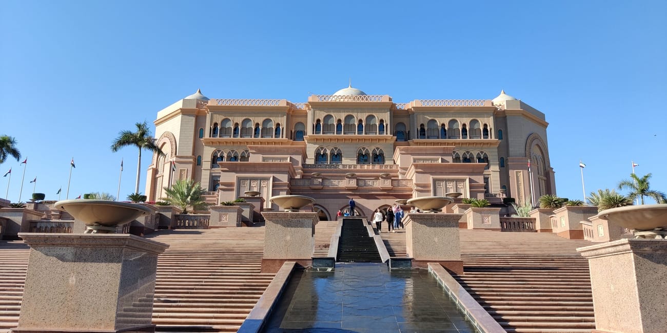 Emirates palace w abu zabi z monumentalnymi schodami i fontanną na pierwszym planie
