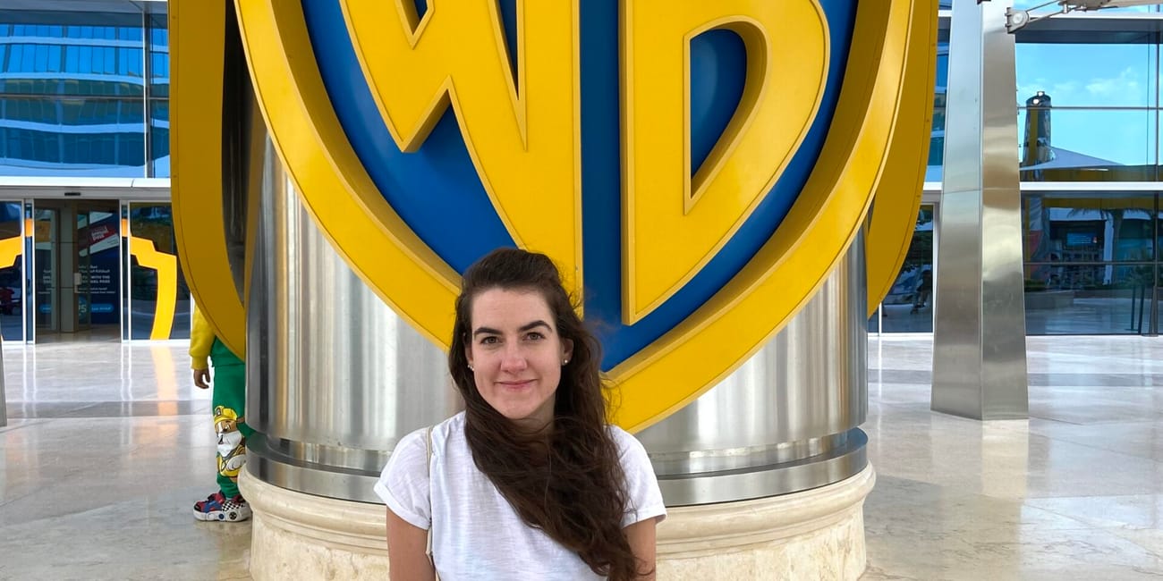 Kobieta siedzi przed dużym logo warner bros w abu dhabi w zea.