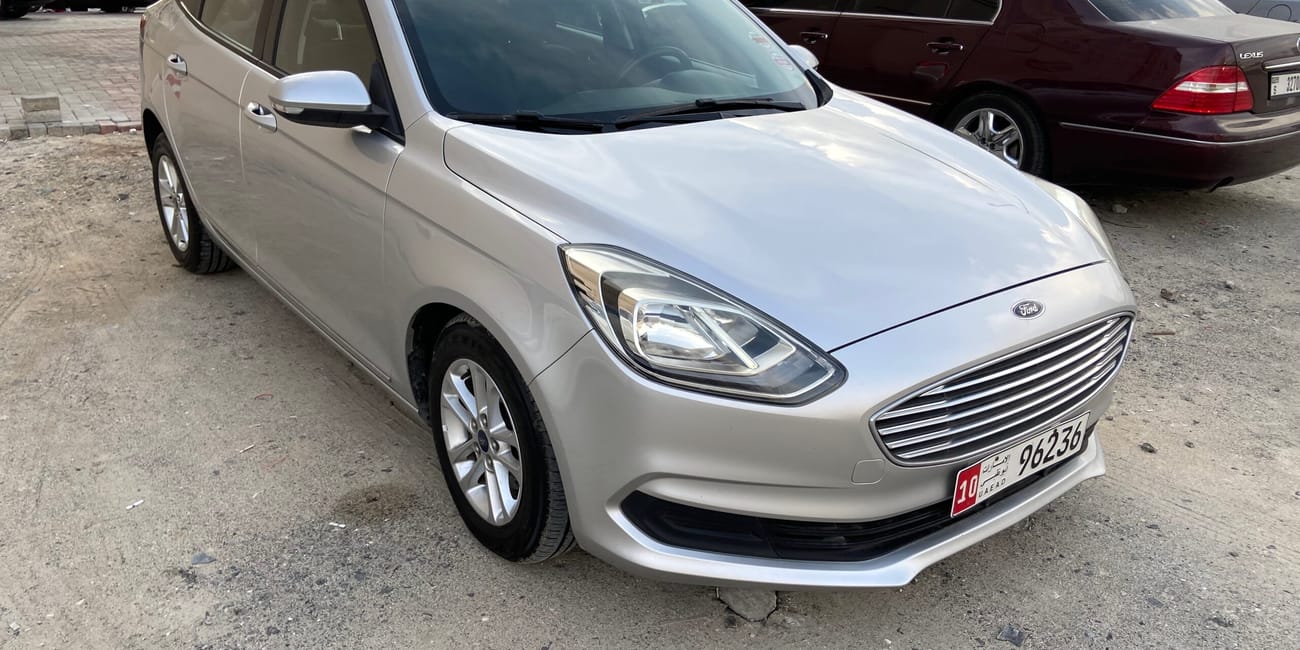 Wynajem samochodu w dubaju, srebrny sedan ford na parkingu