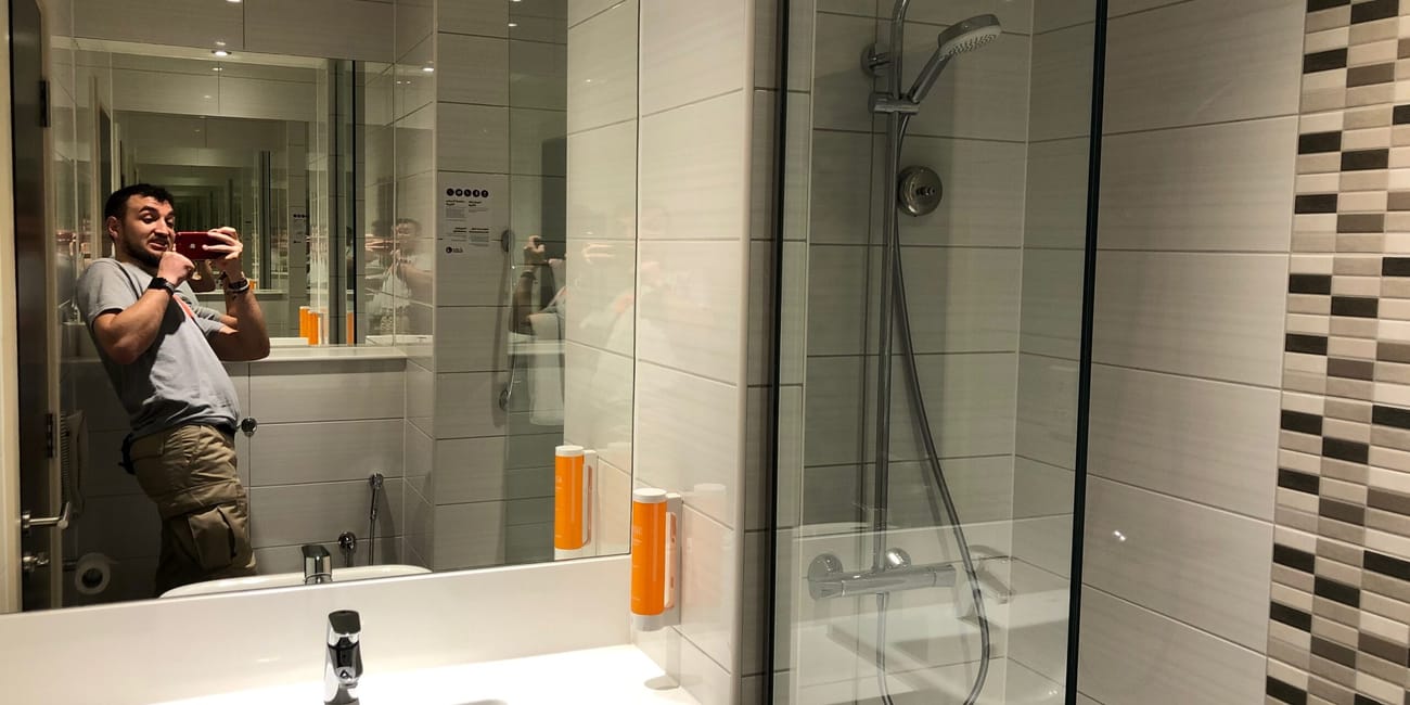 Łazienka hotelowa w dubaju z lustrem, umywalką i kabiną prysznicową.