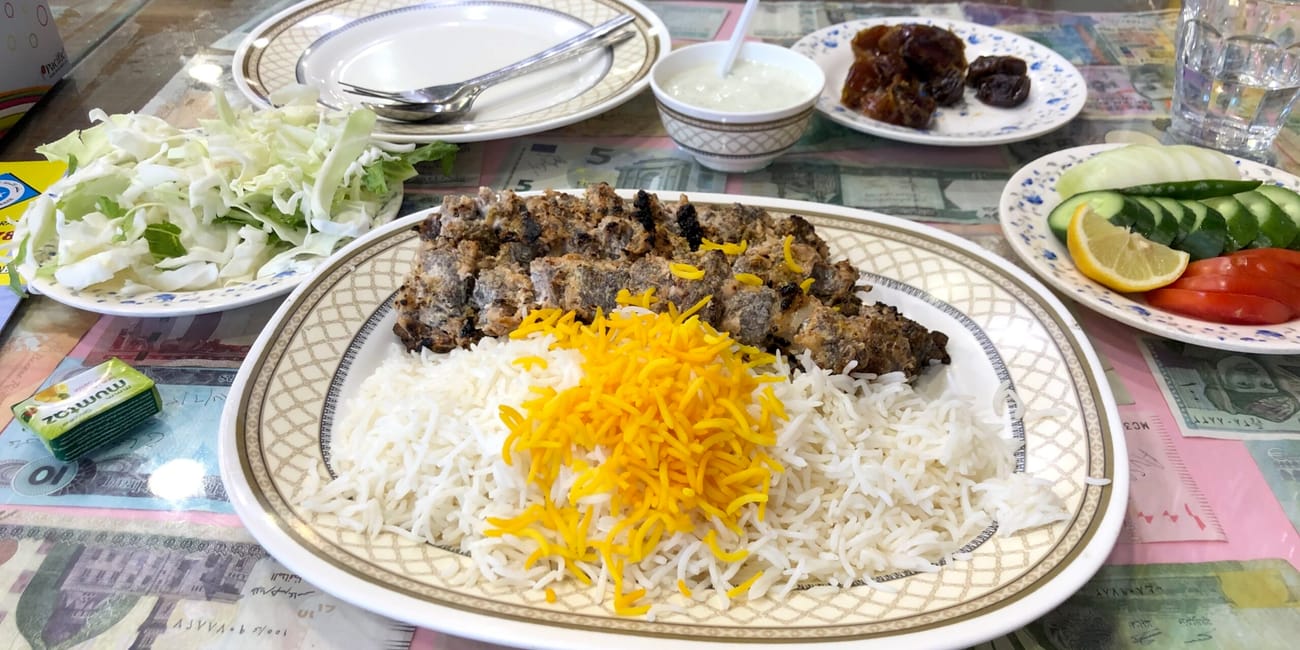 Tradycyjny posiłek w dubai foods w dubaju: ryż z grillowanym mięsem i dodatkami