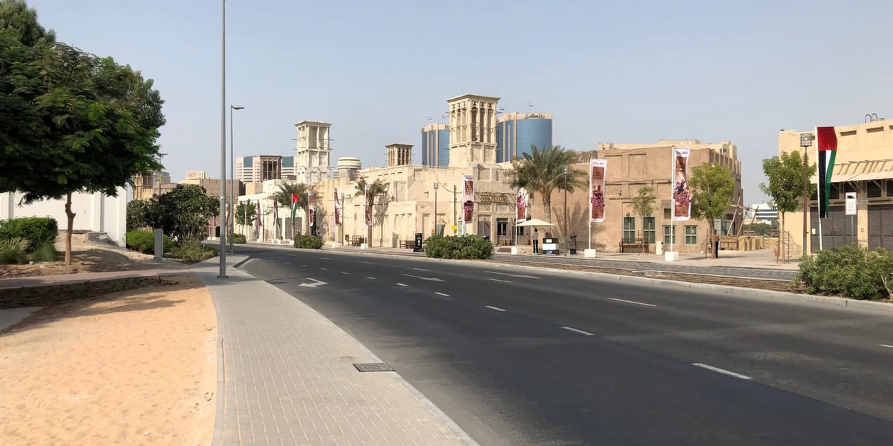 Uliczka w dzielnicy al fahidi w dubaju z tradycyjną zabudową i nowoczesnymi wieżowcami w tle