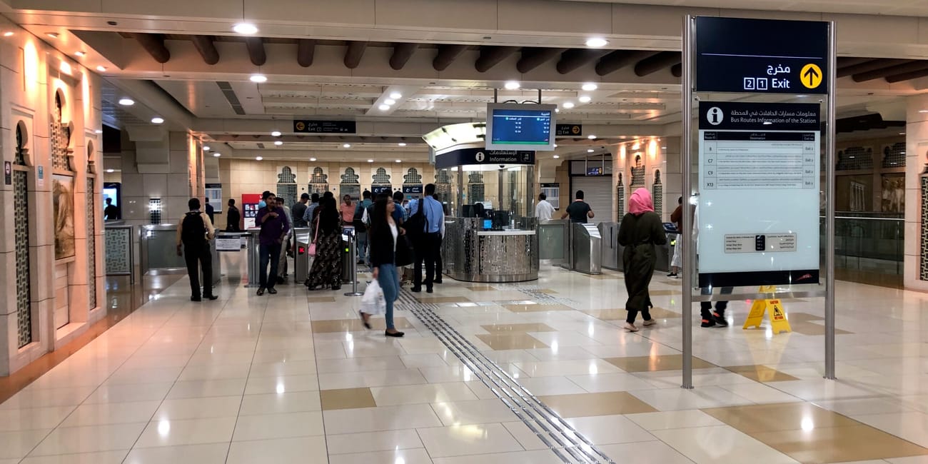 Wnętrze stacji dubai metro w dubaju z pasażerami i oznaczeniami wyjścia
