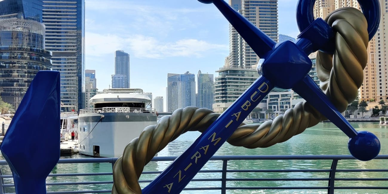 Rzeźba kotwicy w dubai marina na tle wieżowców i nabrzeża