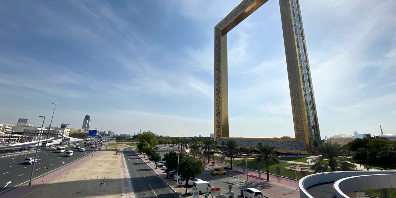 Dubai frame w dubaju górujący nad drogą i okolicznym parkiem pod błękitnym niebem
