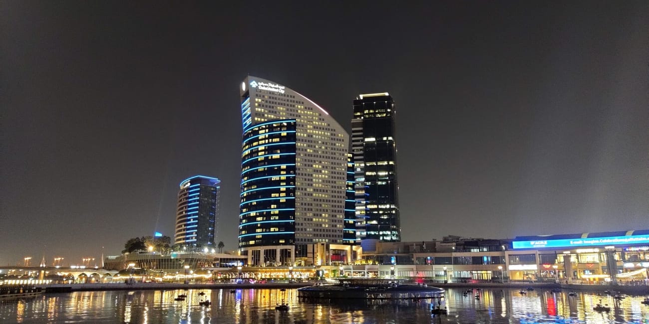 Dubai festival city nocą z podświetlonymi wieżowcami nad wodą