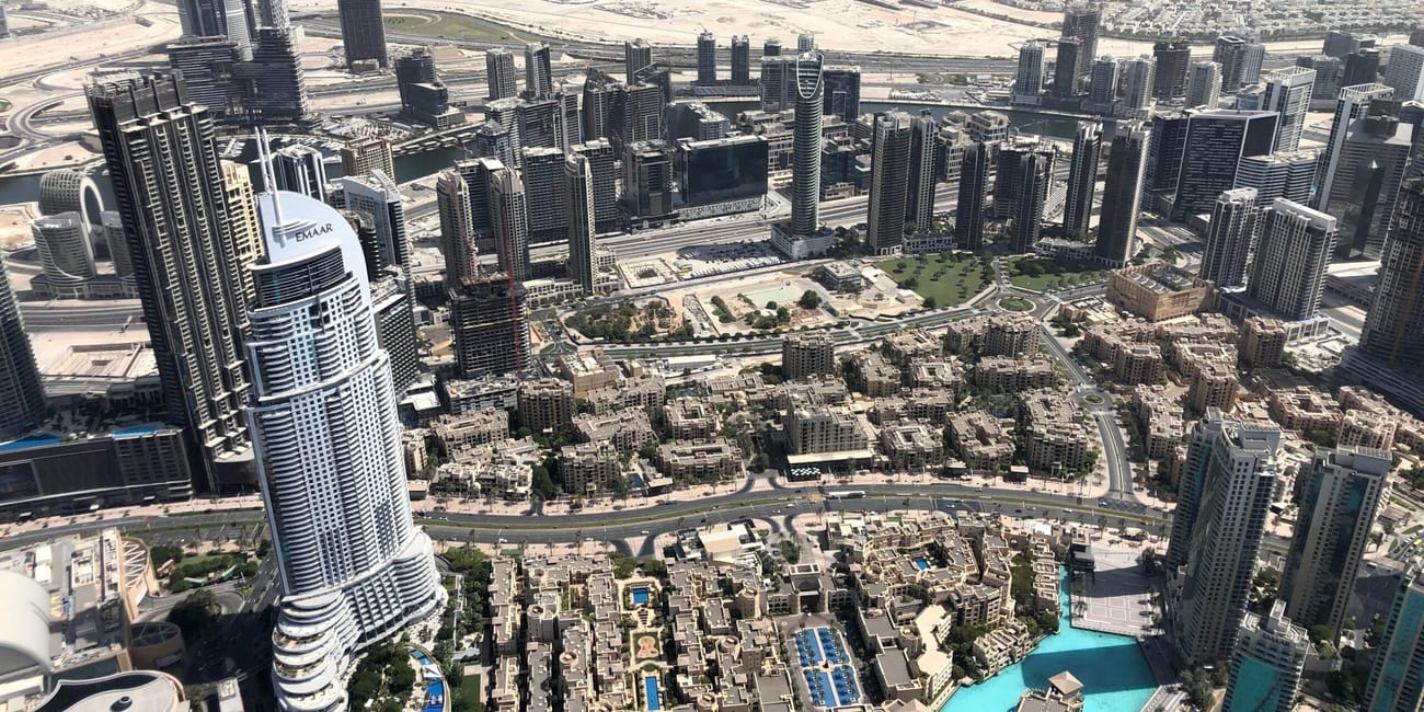 Panorama wieżowców i lagun w centrum dubaju, z wieżowcem emaar na pierwszym planie.