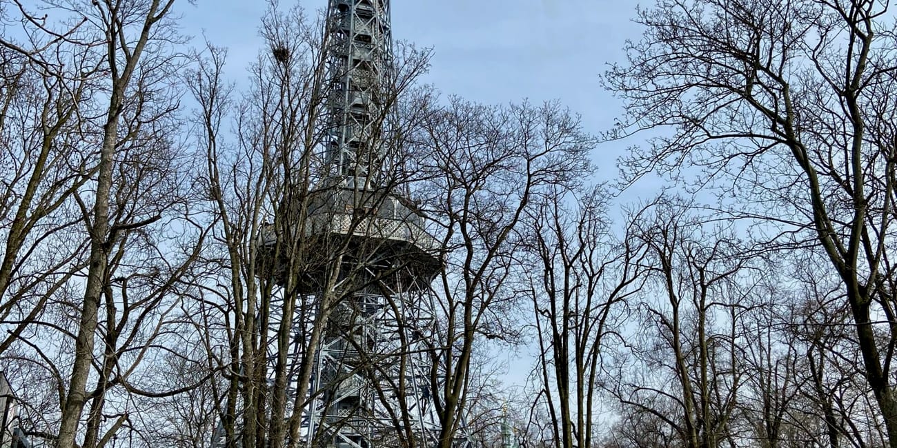 Wieża petřín w pradze, widziana spośród drzew w parku