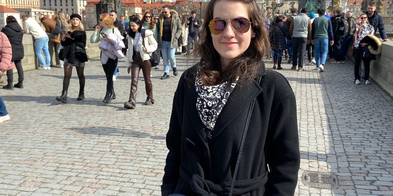 Charles bridge w pradze z turystami i kobietą w okularach na pierwszym planie