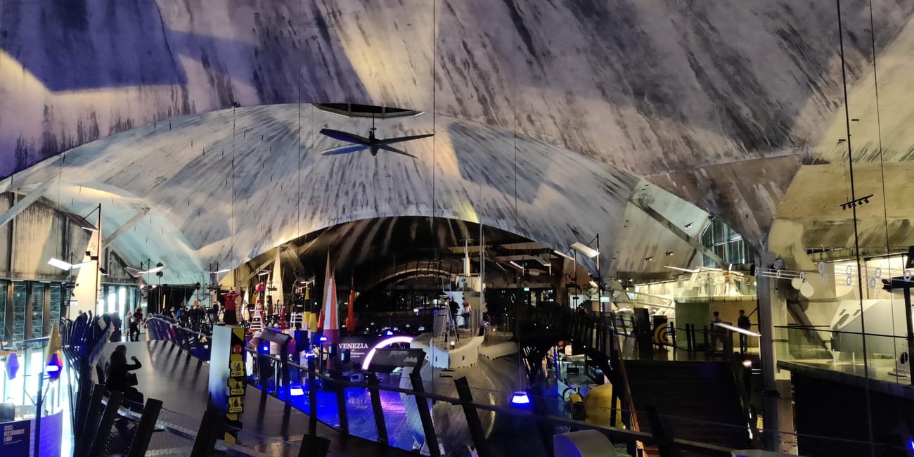 Tallinn article photo inside a modern tunnel-like exhibition with boats and blue lighting