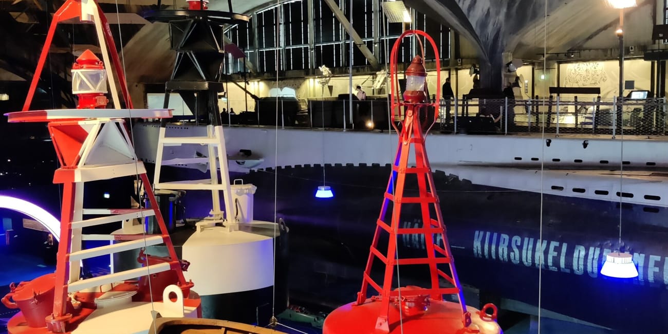 Tallinn article photo inside a submarine museum, showing a red and orange buoy and submarine equipment under lights