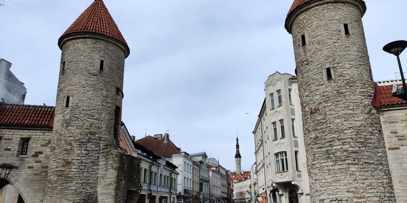 Tallinn old town street with two round stone towers under red-tiled roofs in estonia