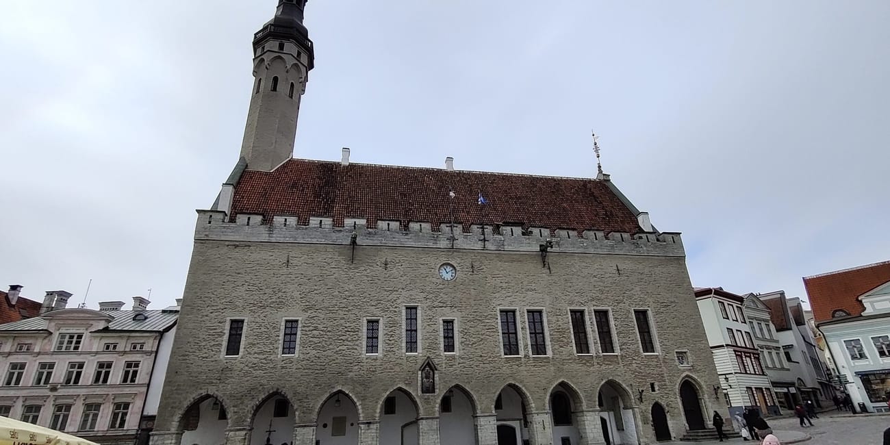 Tallinn church tower and red-roofed building with arched façade in estonia