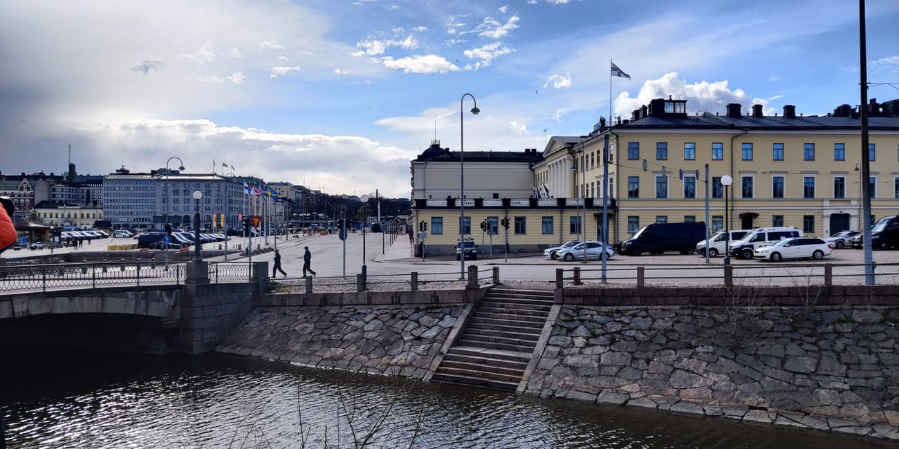 Pałac prezydencki w helsinkach nad nabrzeżem i kanałem przy słonecznym niebie