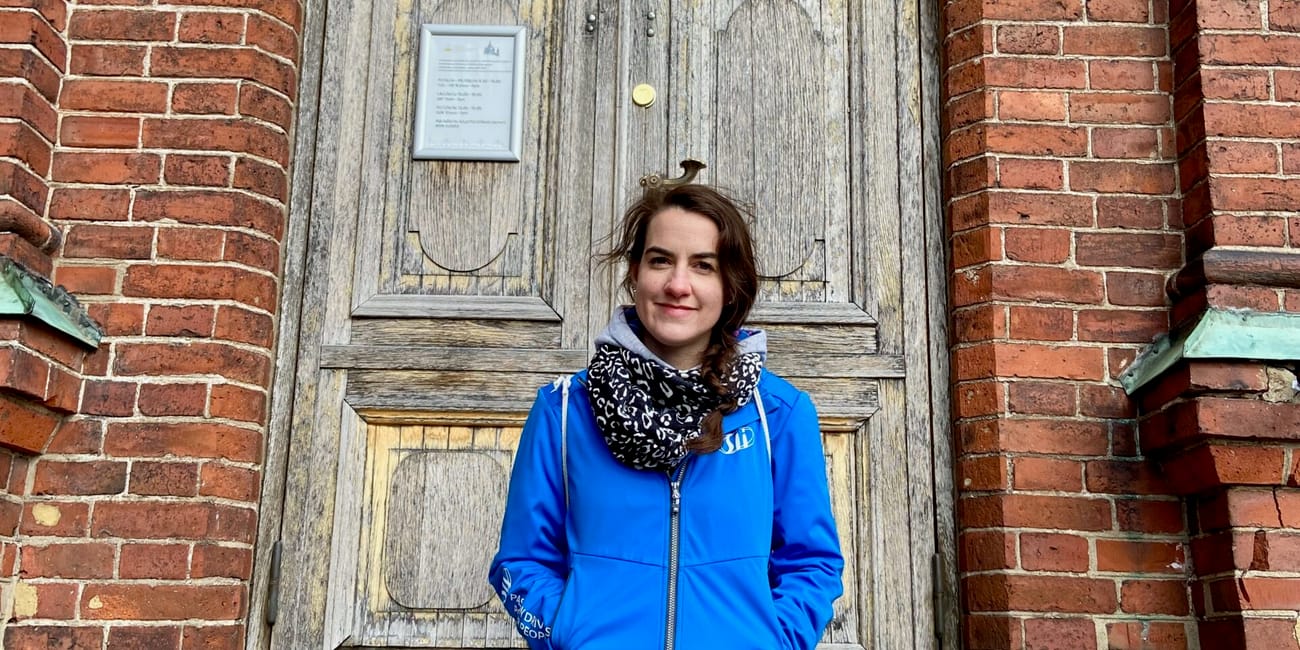Kobieta siedzi przed wejściem do soboru uspieńskiego w helsinkach.