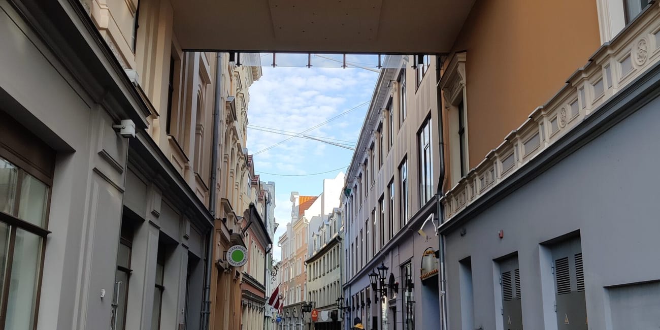 Ulica w rydze, stare miasto, z kamienną nawierzchnią i łącznikiem między budynkami.