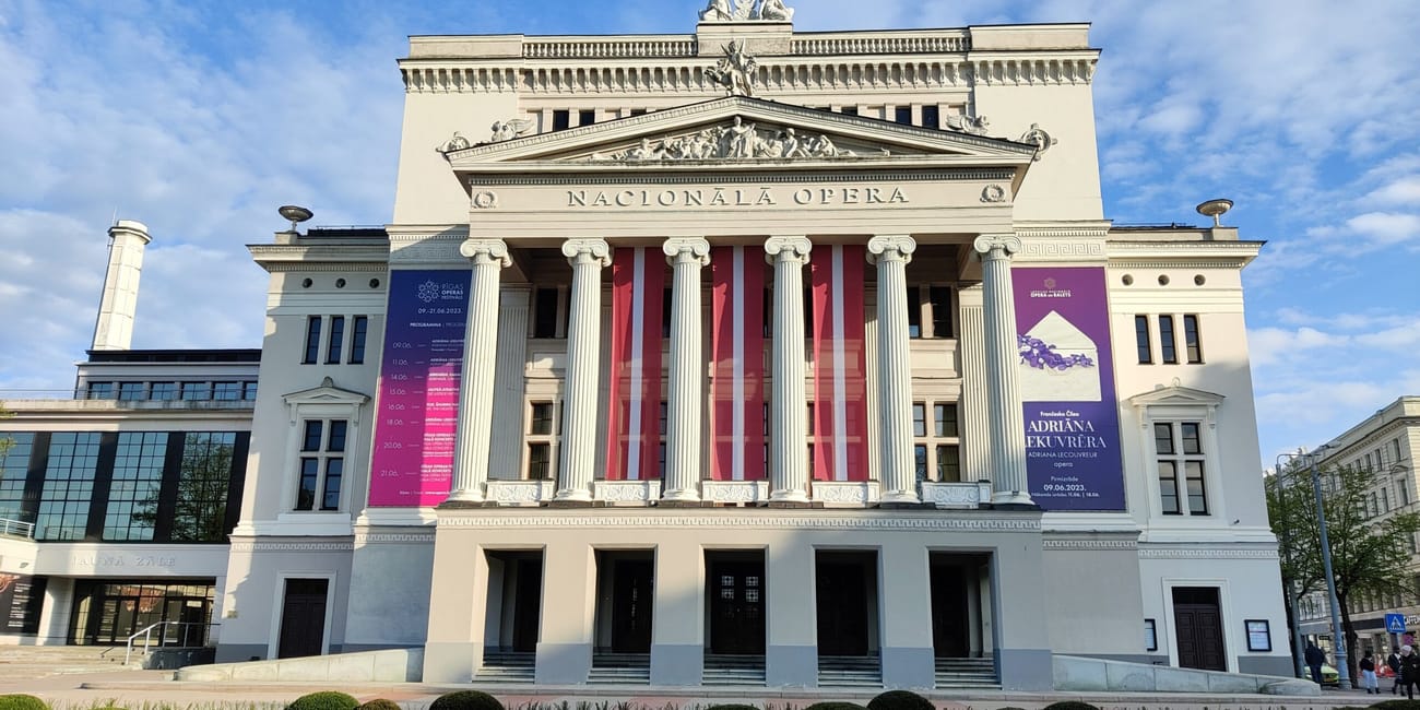 Narodowa opera w rydze z klasyczną fasadą i kolumnami na tle nieba