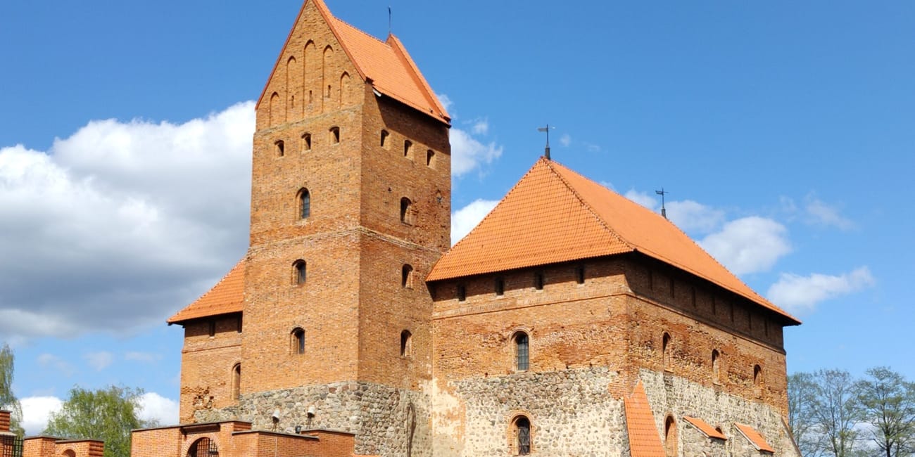 Zamek na wyspie w trokach z ceglanymi wieżami i pomarańczowymi dachami