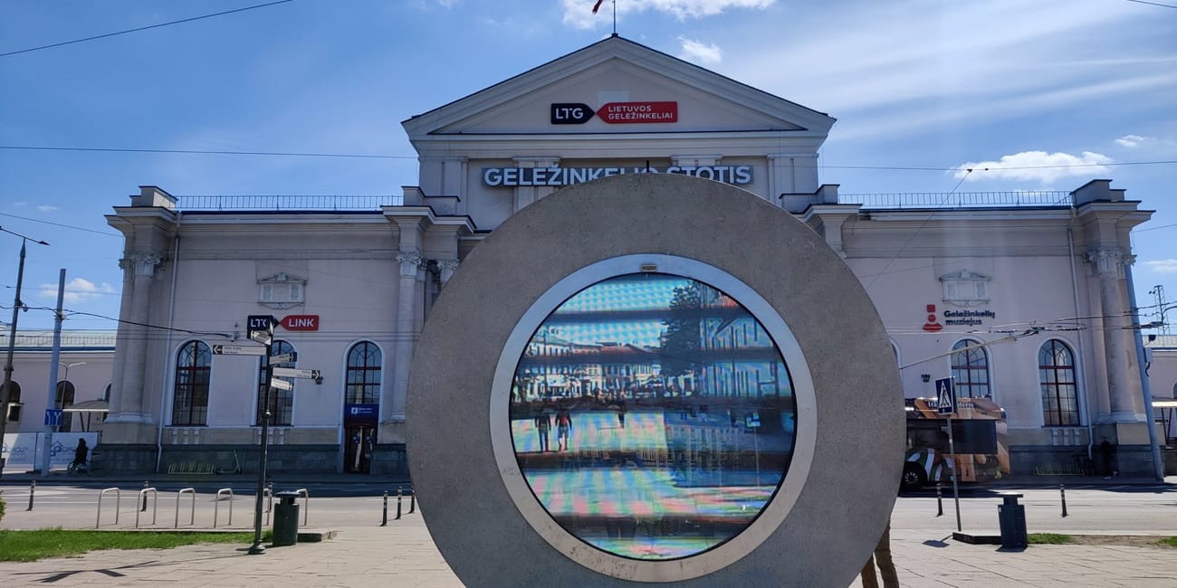 Portal w wilnie przed dworcem kolejowym z nowoczesną okrągłą instalacją.
