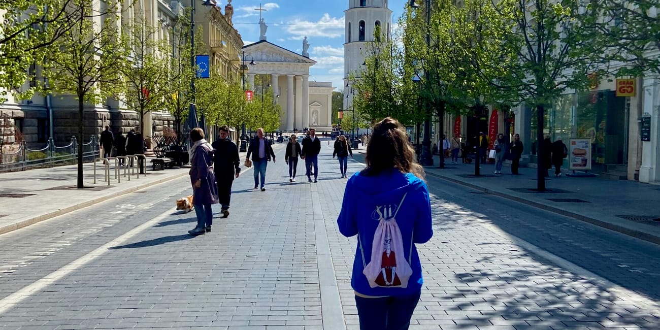 Ulica w wilnie z widokiem na kościół i dzwonnicę na tle błękitnego nieba