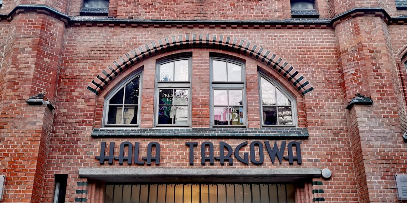 Hala targowa w gdańsku, ceglana fasada z ozdobną rozetą i wieżyczkami