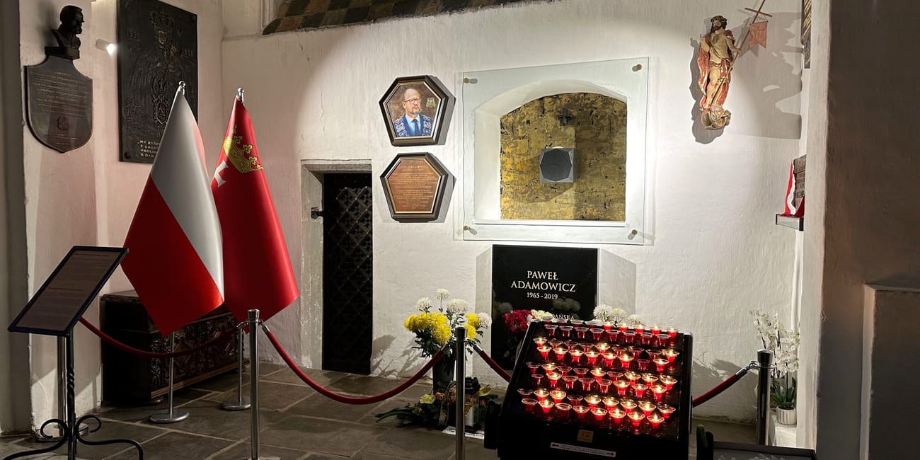 Kaplica pamięci pawła adamowicza w bazylice mariackiej w gdańsku z flagami i płonącymi zniczami