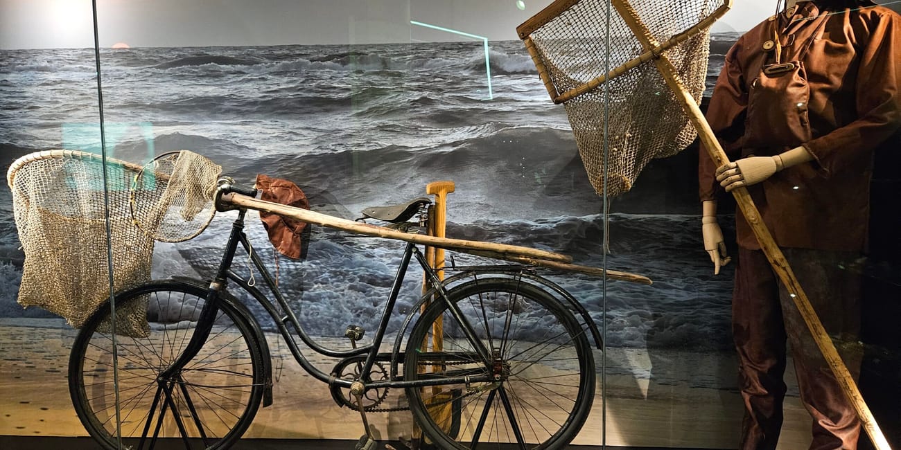 Ekspozycja w muzeum bursztynu w gdańsku z rowerem i strojem dawnego poławiacza bursztynu.