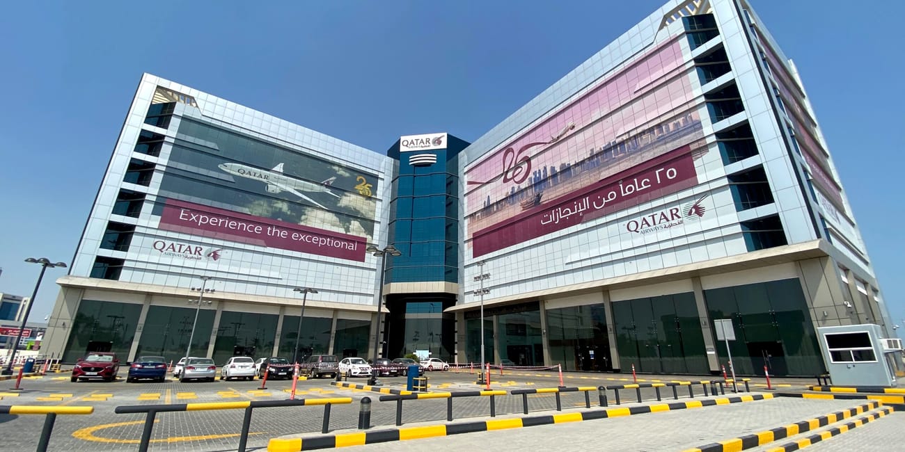 Budynek qatar airways w doha z dużymi reklamami na elewacji