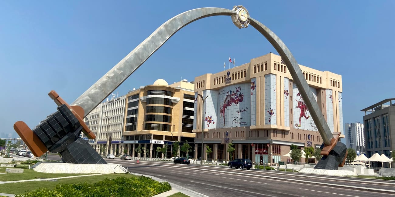 Brama w kształcie sierpa z budynkami w doha, katar