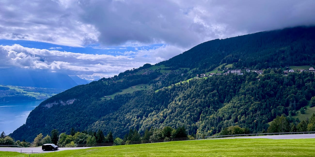 Górski krajobraz nad interlaken w szwajcarii z jeziorem, wzgórzami i drogą na pierwszym planie