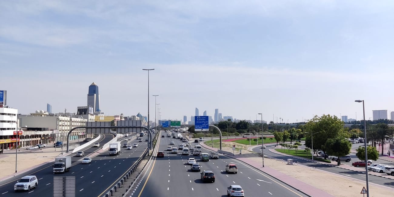 Ruch uliczny na autostradzie w dubaju z samochodami i panoramą miasta w tle
