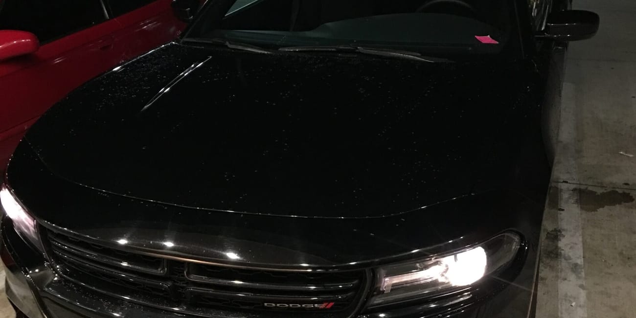 Czarny samochód dodge przy nocnej stacji paliw w los angeles.