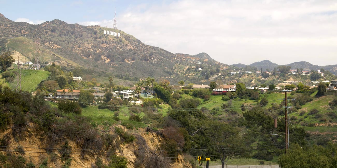 Wzgórza hollywood w los angeles z napisem hollywood i krętą drogą na pierwszym planie