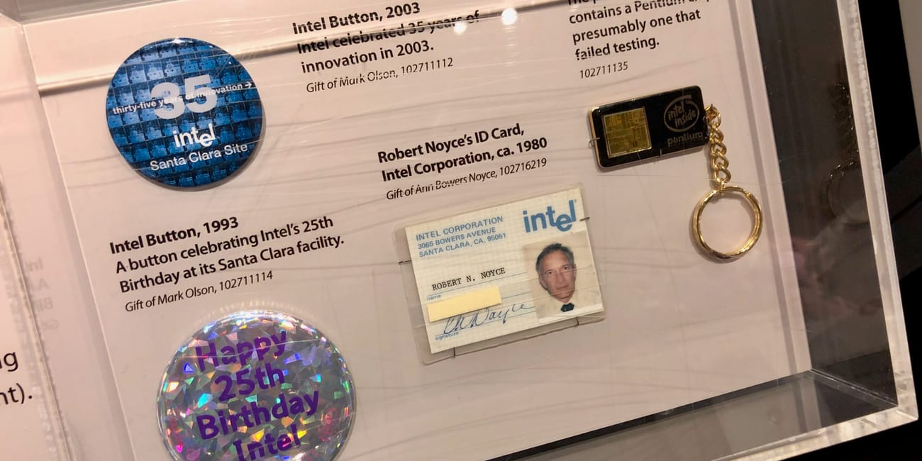 Eksponaty intela w computer history museum w mountain view: przypinki, identyfikator i brelok.