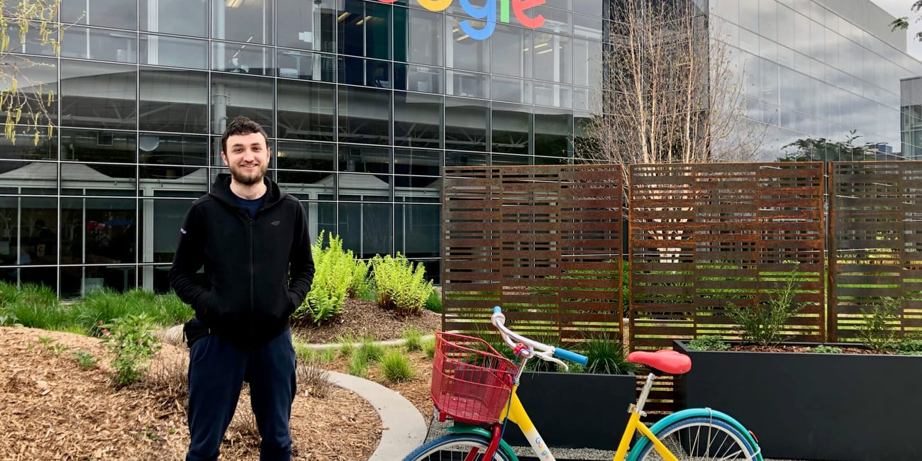 Googleplex w mountain view z kolorowym rowerem i stojącym przed nim mężczyzną