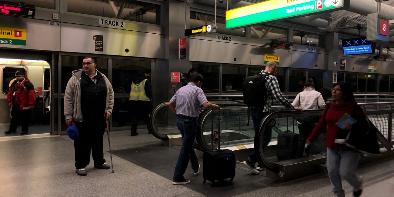 Terminal 8 w nowym jorku z podróżnymi i ruchomymi schodami na peronie kolejowym